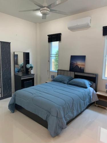 a bedroom with a large bed with a blue comforter at Luxury 3 bed pool villa in Ban Huai Yai