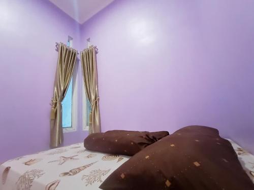 マゲランにあるSeluruh Rumah Karyakita Homestay Magelangのベッドルーム1室(紫の壁のベッド1台、窓付)