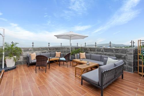 a patio with chairs and tables and an umbrella at Hotel Vista Caribe Azúa in Azua de Compostela