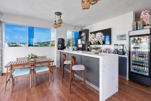 a kitchen with a bar and a table and chairs at Hotel Vista Caribe Azúa in Azua de Compostela