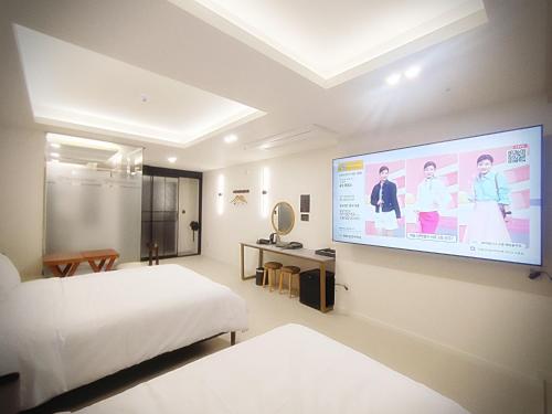 a bedroom with a large projection screen on the wall at Bluebird Hotel in Incheon