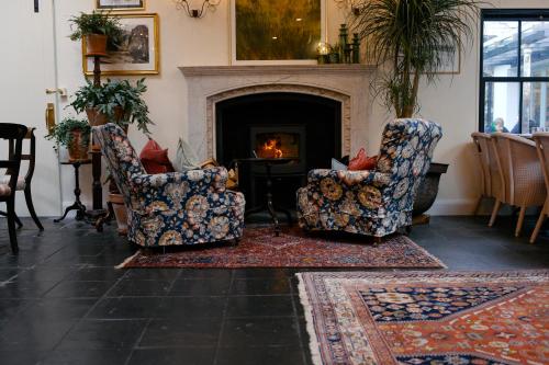 a living room with two chairs and a fireplace at The Coach House in Roundwood