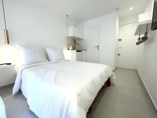 - une chambre blanche avec un lit blanc et une salle de bains dans l'établissement Nid douillet proche Vieux-Port, à Marseille
