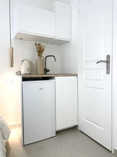 une cuisine avec des armoires blanches et un évier dans l'établissement Nid douillet proche Vieux-Port, à Marseille