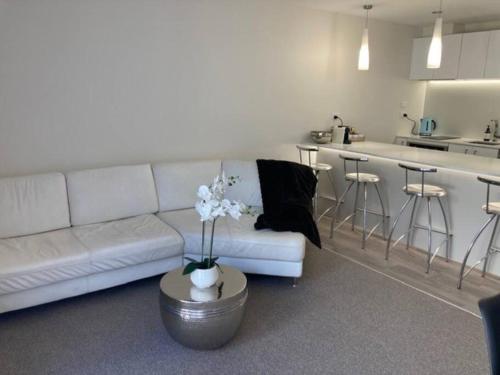 a living room with a white couch and a kitchen at Two Bedroom Guest House in Remuera Auckland in Auckland