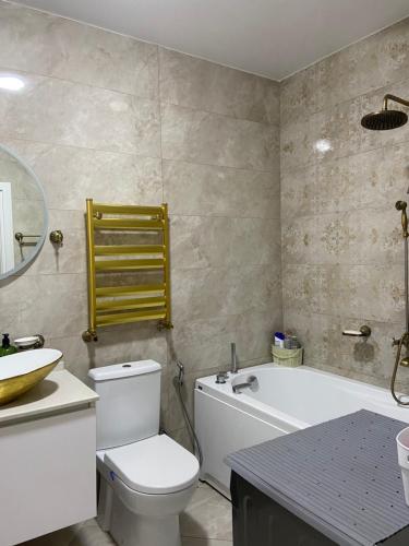 a bathroom with a tub and a toilet and a sink at Панорама-Батуми in Batumi
