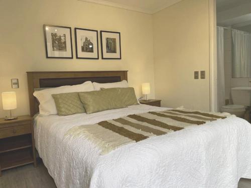 a bedroom with a large bed with two lamps on it at Barrio Lastarria, Excelentes Apartamentos - Sofia Camilla Propiedades in Santiago