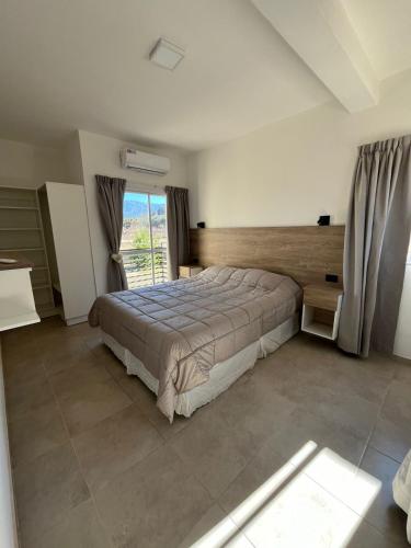a bedroom with a large bed and a window at Cabañas Balcón del Famatina in Chilecito