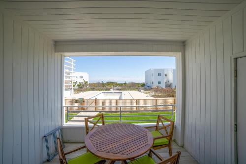 a porch with a table and two chairs and a window at The Hermitage at Napeague in Amagansett