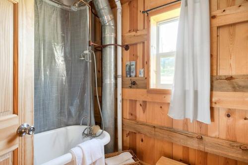 a bathroom with a bath tub and a window at The Rustic Retreat in Pearl City