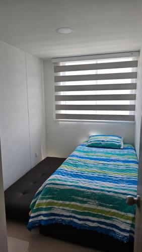 a bedroom with a bed in front of a window at Estadía Familiar in Ibagué