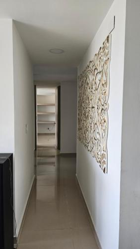 a hallway with a white wall with a painting on it at Estadía Familiar in Ibagué