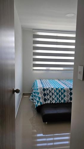 a bedroom with a bed and a window with blinds at Estadía Familiar in Ibagué
