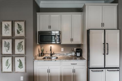 a kitchen with white cabinets and a sink and a microwave at The Guest Suite in Gallatin