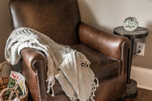 a brown leather chair with a blanket on it at The Guest Suite in Gallatin