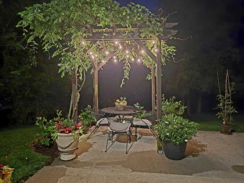 a table and chairs under a pergola with plants at The Guest Suite in Gallatin