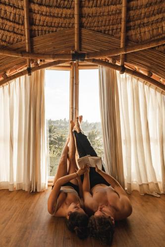 two women laying on the floor reading a book at Aranka Tempasan in Sangyang