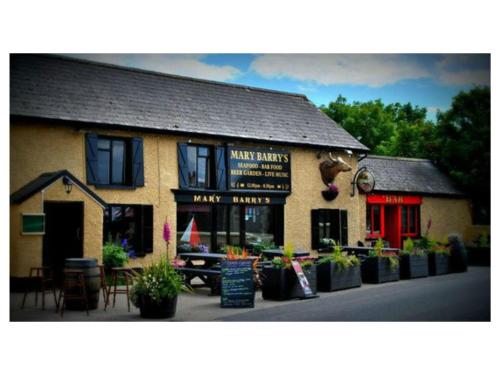 a building with a restaurant with plants in front of it at Ambrose Mews B&B in Duncormick