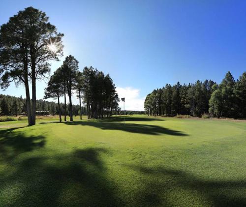 a golf course with trees and a green field at The Bluejay Cabin at Munds Park, AZ! in Sedona