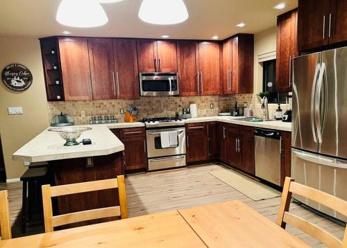 a kitchen with wooden cabinets and stainless steel appliances at The Bluejay Cabin at Munds Park, AZ! in Sedona