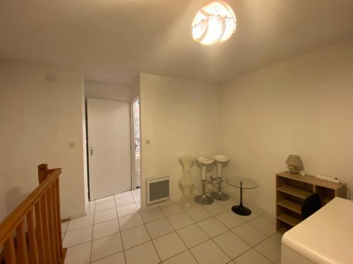 une grande pièce blanche avec un escalier et un luminaire dans l'établissement Appartement Duplex Calme, Proche Plage et Centre à Fouras - FR-1-709-78, à Fouras