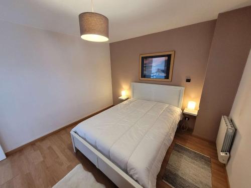 - une chambre avec un lit blanc et deux lumières dans l'établissement Appartement T2 avec Balcon Sud - Plage et Centre-Ville Proches - FR-1-674-47, à Berck-sur-Mer