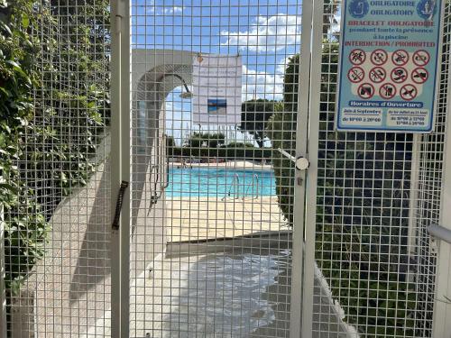 une porte avec une porte avec une piscine derrière elle dans l'établissement Appartement avec Piscine, Terrasse et Climatisation - 5 Couchages - Grau-du-Roi - FR-1-250-290, au Grau-du-Roi