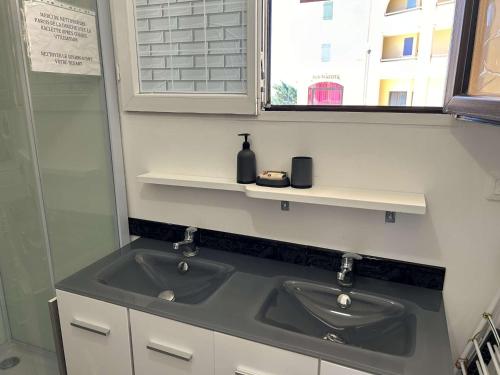 une salle de bain avec un lavabo et une fenêtre dans l'établissement Appartement T2 avec Piscine et Tennis, Proche Plage, Parking Privé - 6 Couchages, Saint Pierre La Mer - FR-1-229D-134, à Fleury