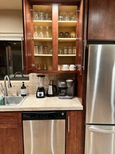 a kitchen with a stainless steel refrigerator and a sink at The Bluejay Cabin at Munds Park, AZ! in Sedona