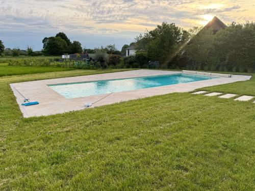- une piscine au milieu d'une pelouse dans l'établissement Maison contemporaine avec piscine et jardin, proche de Bourges - FR-1-586-43, à Saint-Éloy-de-Gy