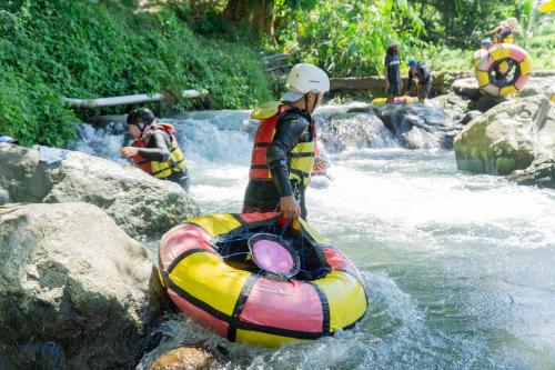 a man is standing next to a raft in a river at Aranka Tempasan in Sangyang