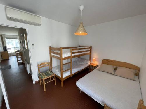 une chambre avec deux lits et un lit superposé dans l'établissement Appartement T3 Climatisé, 6 Pers, Proche Plage et Commerces, Parking Privé, Animaux Admis - FR-1-106-104, à Saint-Cyprien