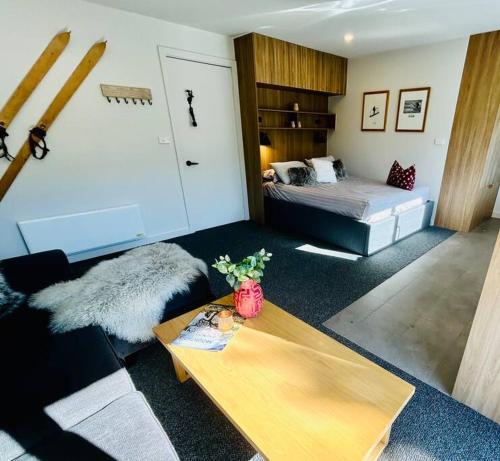 a living room with a bed and a table at First Tracks Studio in Thredbo