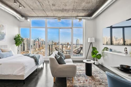 a bedroom with a bed and a large window at Studio Just Steps from Stampede Park, Luxury Living in Calgary