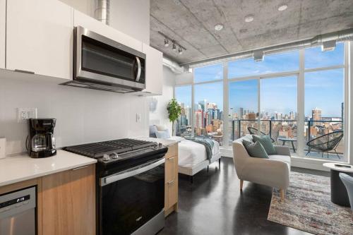 a kitchen with a stove top oven next to a living room at Studio Just Steps from Stampede Park, Luxury Living in Calgary