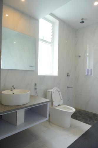 a white bathroom with a sink and a toilet at La grande suite karaikal in kāraikāl
