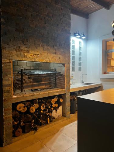 eine Küche mit einem gemauerten Kamin mit Holzscheiten in der Unterkunft Casa barrio privado in Laguna Brava