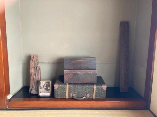 a shelf with three stacks of boxes and a clock at 小グループ専門貸切一軒家 パーティーOK観光スポット徒歩圏内 小諸駅歩2分揚羽屋 Specializing in small groups, Party OK, Walking to tourist spots, Vacation Rental House 2 min from Komoro sta in Komoro