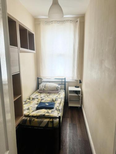 a small room with a bed and a window at Nice and Pleasant in Thornton Heath