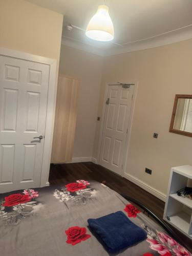 a room with a bed with red roses on the floor at Nice and Pleasant in Thornton Heath