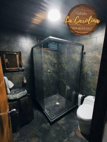 a bathroom with a toilet and a glass shower at Cabaña La Carolina in Ibagué
