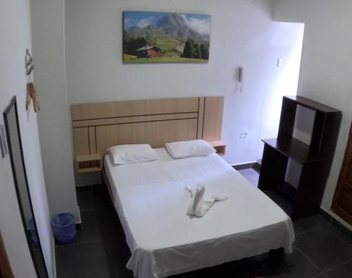 a bedroom with a bed with a white towel on it at Royal Ventura Hotel in Pucallpa