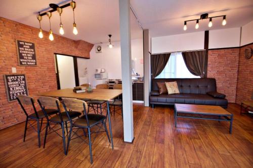 a living room with a table and chairs and a couch at TOMARIE Horikiri Residential Suite in Tokyo