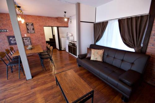 a living room with a couch and a table at TOMARIE Horikiri Residential Suite in Tokyo