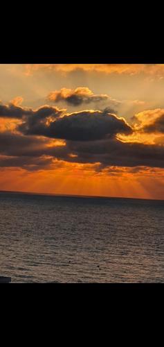 an image of a sunset over the ocean at Appt magnifique vue mer et piscine spacieuse in Sidi Bouqnadel