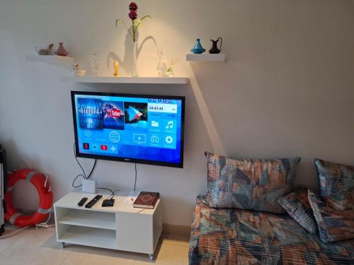 a living room with a tv and a couch at Appt magnifique vue mer et piscine spacieuse in Sidi Bouqnadel