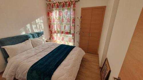 a bedroom with a bed and a window at Appt magnifique vue mer et piscine spacieuse in Sidi Bouqnadel
