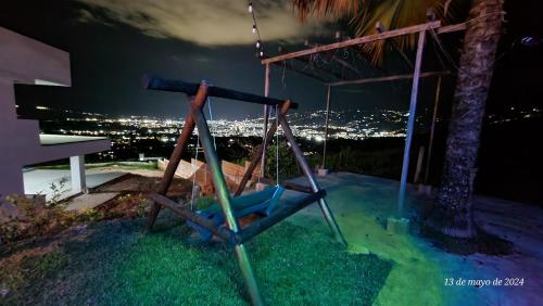 a swing on the side of a house at night at Hospedaje Campestre El Manantial in Floridablanca