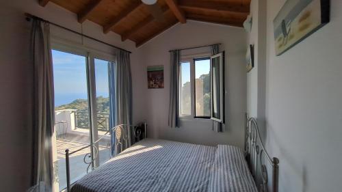 a bedroom with a bed and a large window at Villa Luna Home in Vourliótai
