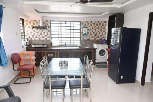una cocina con mesa de cristal y sillas. en Beautiful GardenTerrace 2 Bhk in Posh city center, en Bhubaneshwar